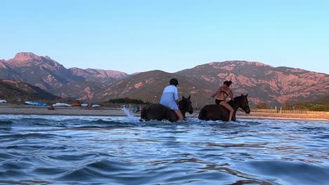 People-bathing-while-riding-horses-in-seawater-in-summer-season
