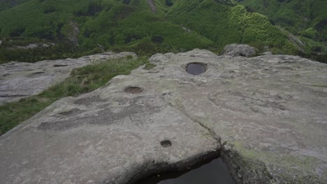 Drone-tilting-over-the-top-of-Belintash-Plateau,-revealing-a-carved-ritual-pool,-situated-in-Rhodope-Mountains-in-the-province-of-Plovdiv-in-Bulgaria