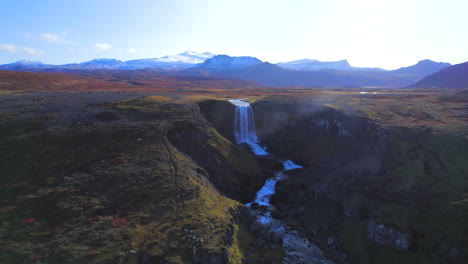 Aerial-of-waterfall-of-Iceland-flowing-from-glacial-valley-in-fall-season