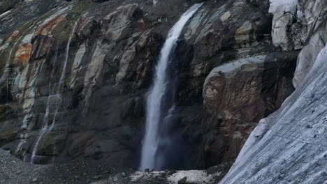 Waterfall-stream-flowing-from-glacier-along-rocky-wall