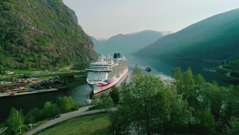 Filmische-Establishment-Aufnahme-Des-Kreuzfahrtschiffes-Britannia-In-Einem-Fjord,-Flaggschiff-Der-PO-Kreuzfahrt-In-Norwegen,-Dorf-Flam