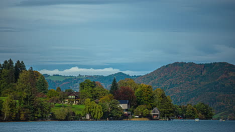 Quaint-homes-overlook-Lake-Attersee-Austria-as-clouds-rush-by-mountains