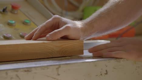 Close-up-Shot-Of-Hand-Placed-On-Wooden-Board-In-Workshop