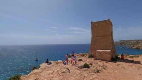 Tourist-visiting-Lippija-Tower-in-Malta-island,-pan-left-view