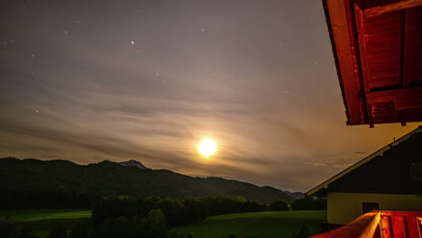 Timelapse-of-moon-setting-as-stars-move-across-sky-on-cloudy-evening