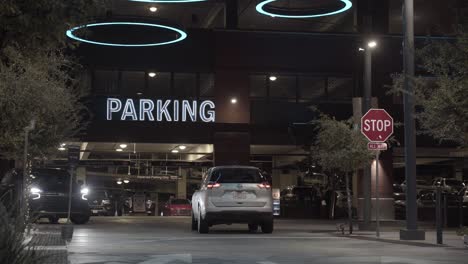 Cars-Drive-In-and-Out-of-Downtown-Parking-Garage-with-a-Giant-LED-Parking-Sign