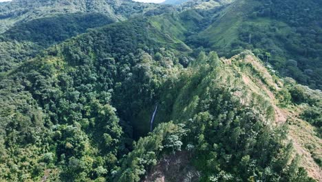 Orbit-shot-of-a-towering-epic-waterfall-falling-into-the-jungle-in-the-Salto-del-Rodeo-region-of-Bonao-of-the-Dominican-Republic