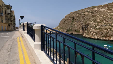 Beautiful-handrail-and-sea-bay-near-Maltese-town,-dolly-forward-view