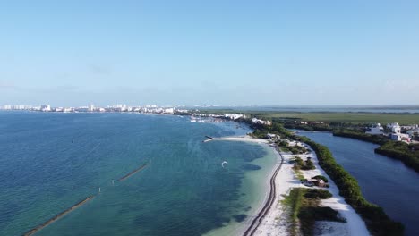 Luftdrohnenaufnahme-Der-Küste-Von-Cancun,-Mit-Hotels-In-Der-Ferne-Und-Einem-Kitesurfer-über-Dem-Klaren-Blauen-Meerwasser