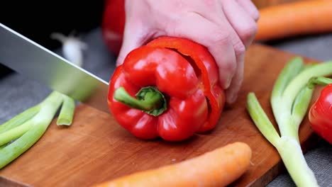 Fresh-peppers-cut-up-by-cook-on-wooden-chopping-board