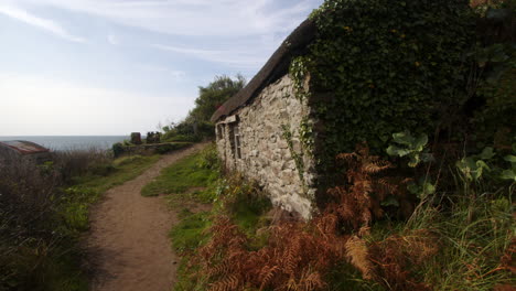 Mid-shot-looking-up-at-old-fisherman's-cottage-at-Bessy's-Cove,-The-Enys-,-cornwall
