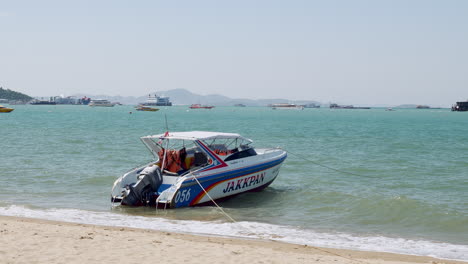 A-single-motor-speedboat-moored-on-the-beach-in-Chonburi-waiting-to-be-taken-by-tourists-for-an-island-hopping-or-diving-experience,-Pattaya,-Thailand