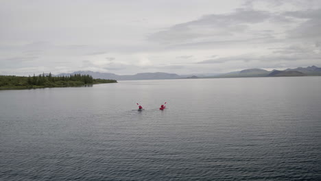 Hestvik-lake-and-landscape-aerial-orbital-in-Iceland-following-two-kayaks