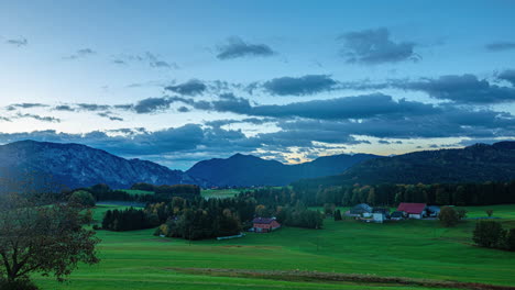 Clouds-fly-over-verdant-Attersee-countryside-during-sunrise-time-lapse,-Austria