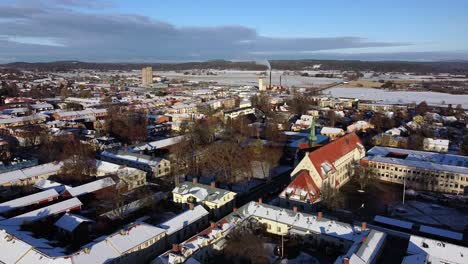 Quaint-snow-covered-apartment-roof-tops-of-suburban-Scandinavian-town-in-Sweden,-aerial-establish