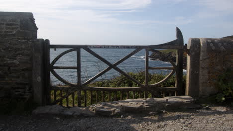wide-shot-of-an-ornate-wooden-gate-at-Bessy's-Cove,-The-Enys