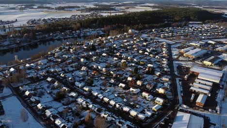 High-angle-aerial-pan-across-Scandinavian-suburban-small-town-with-snow-covered-roofs