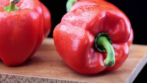 Fresh-red-peppers-on-wooden-chopping-board,-close-up-pan