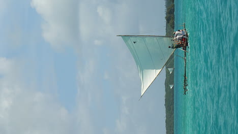 Sailing-on-a-pirogue-or-outrigger-canoe-on-majestic-Upy-bay-in-New-Caledonia---vertical-orientation