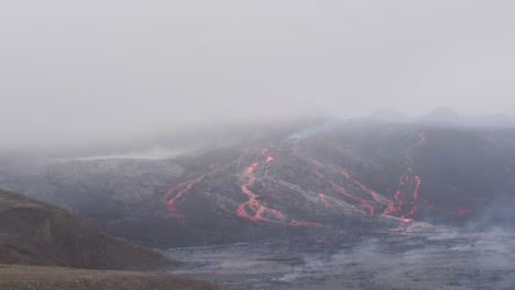 Fagradalsfjall-volcano-in-Iceland-aerial-tracking-shot-of-lava-flow-streaming-down-hillside