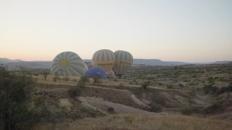 Heißluftballons,-Die-Am-Frühen-Morgen-Eine-Epische-Landschaft-Aufblasen