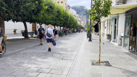 People-walking-on-a-sunny-street-in-Sorrento,-Italy