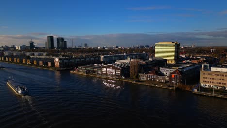 Ships-passing-on-IJ-river-next-to-Amsterdam-Noord-Vogelbuurt-drone-fixed-shot
