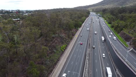 Drone-flying-over-a-multi-lane-freeway-cars-and-trucks-passing-by