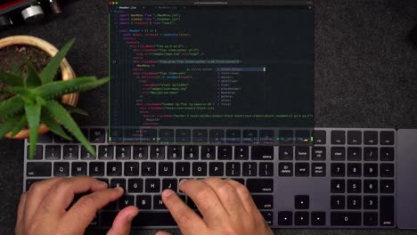 Programmer-Hands-Typing-Real-Javascript-Code-on-Black-Keyboard-with-Projected-Computer-Screen