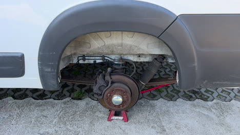 Rusty-car-brake-disc-and-caliper-on-jack-stand