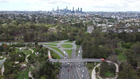 Aerial-view-of-a-major-freeway-with-a-roundabout-and-city-skyline