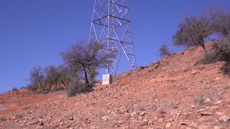 High-Voltage-Electric-Tower-Against-a-Clear-Blue-Sky,-Tilt-Camera-Movement