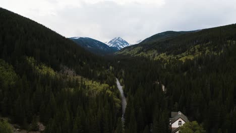 Aerial-view-flying-through-a-valley-of-trees-in-the-Rocky-Mountains-with-James-Peak-sitting-at-the-end