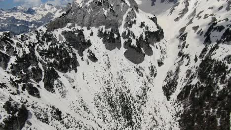 Vista-De-Drones-En-Albania-Volando-En-Los-Alpes-Mostrando-Una-Montaña-Nevada-Y-Rocosa-En-Theth