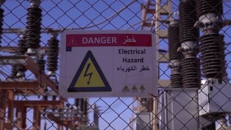 Electrical-Safety-Warning:-Danger-Sign-for-Electrical-Hazard-in-Multiple-Languages-on-Chain-Link-Fence-at-Power-Substation