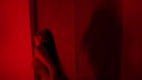 Atemberaubende-Rotlichtvorstellung-Einer-Wunderschönen-Tänzerin-Allein-In-Einem-Raum