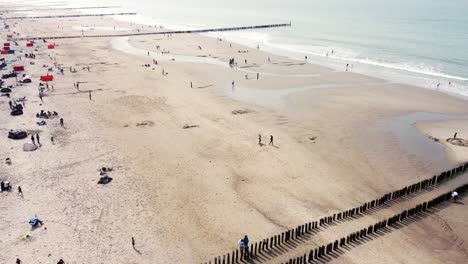 Großer,-überfüllter-Strand-Mit-Mehreren-Langen-Buhnen-In-Den-Niederlanden