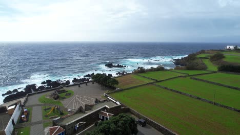 Coastal-highway-with-farmlands-next-to-Varadouro-pools-in-Azores