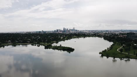 Drone-shot-pulling-away-from-Sloan-Lake-with-Denver,-Colorado-in-the-backdrop