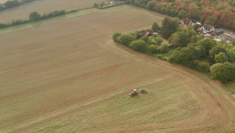 Wide-circling-aerial-shot-of-a-tractor-ploughing-a-large-field