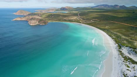 Aerial-view-of-a-4WD-car-driving-in-the-beach,-waves---Lucky-Bay,-Australia---dolly,-drone-shot