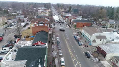 Dynamic-flying-aerial-shot-of-Niagara-on-the-Lake's-downtown-courthouse,-continuing-down-the-main-street-that-has-historical-buildings