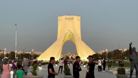 People-are-walking-in-Tehran-Iran-Azadi-shahyad-tower-in-freedom-square-and-emigrant-have-video-call-with-his-family-downtown-city-center-in-middle-east-asia-weekend-tourist-visit-landmark-attraction