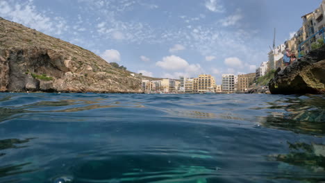 Ein-Blick-Auf-Wasserspiegel-Zwischen-Den-Felsen-Auf-Eine-Stadt-Auf-Der-Insel-Malta