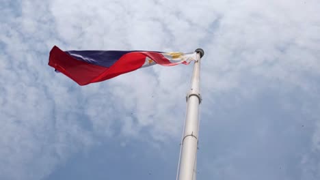 Wunderschöne-Philippinische-Nationalflagge,-Die-Nach-Links-Weht,-Mit-Starkem-Wind,-Darüber-Fliegende-Vögel-Und-Schöne,-Flauschige-Wolken-Am-Himmel