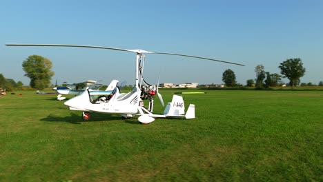 Drone-flying-around-ultralight-aircraft-parked-in-green-airfield-flight-school-of-Italy