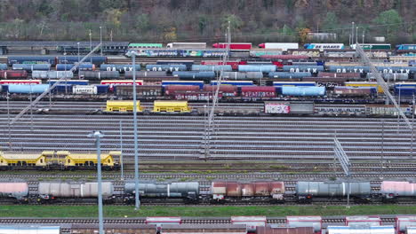 Tren-Que-Transportaba-Camiones-Pasando-Por-El-Depósito-De-Trenes-De-Carga-En-Muttenz,-Suiza