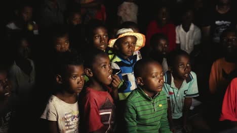 Black-Malagasy-children-concentrated-while-watching-television---stable-shot