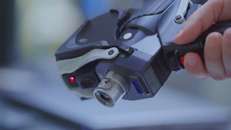 Hand-hold-futuristic-laser-scanner-and-pushes-red-button