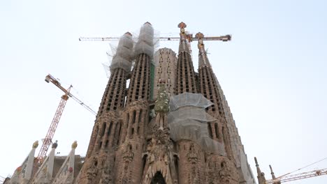 Tilt-down-shot-of-the-Sagrada-Familia,-the-largest-unfinished-Catholic-church-in-the-world-and-part-of-a-UNESCO-World-Heritage-Site